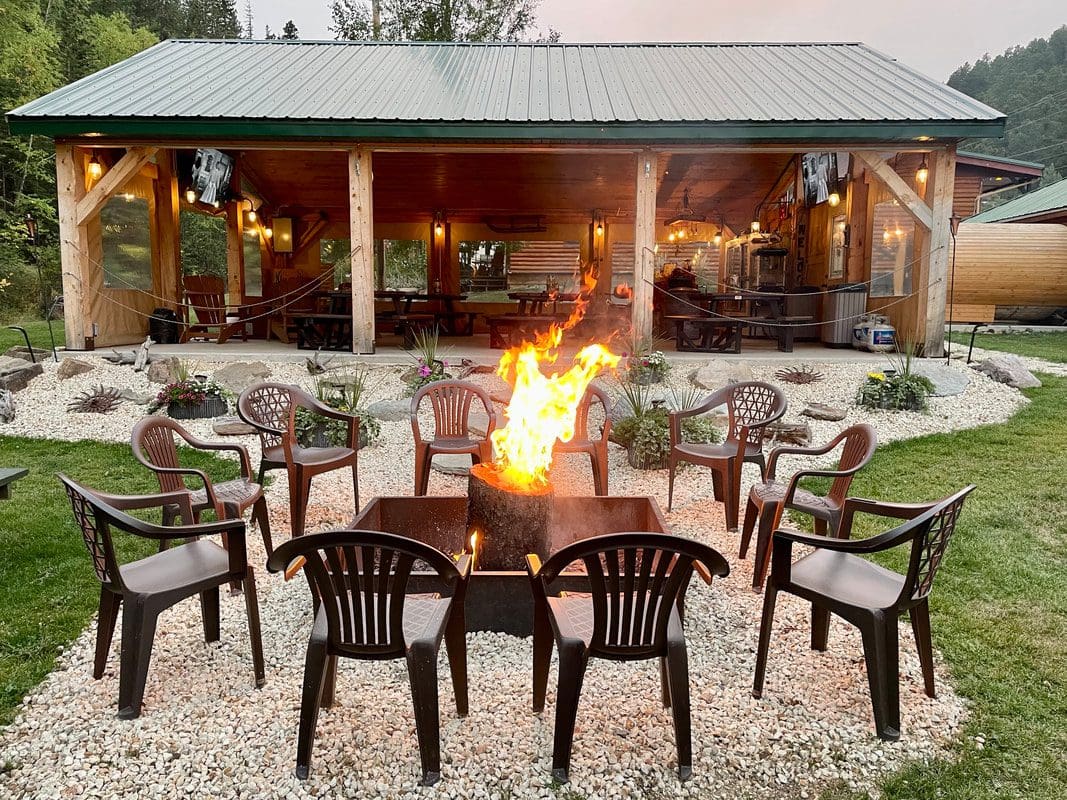 Fire pit pavilion surrounded by lawn chairs and succulents